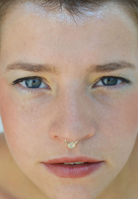 Silver septum spiral nose piercing