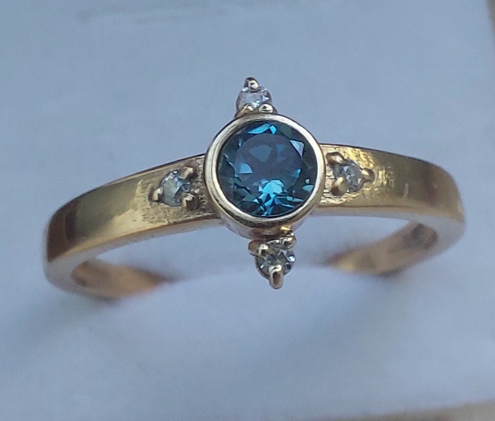 Gold Engagement ring with dark Blue Topaz and diamonds